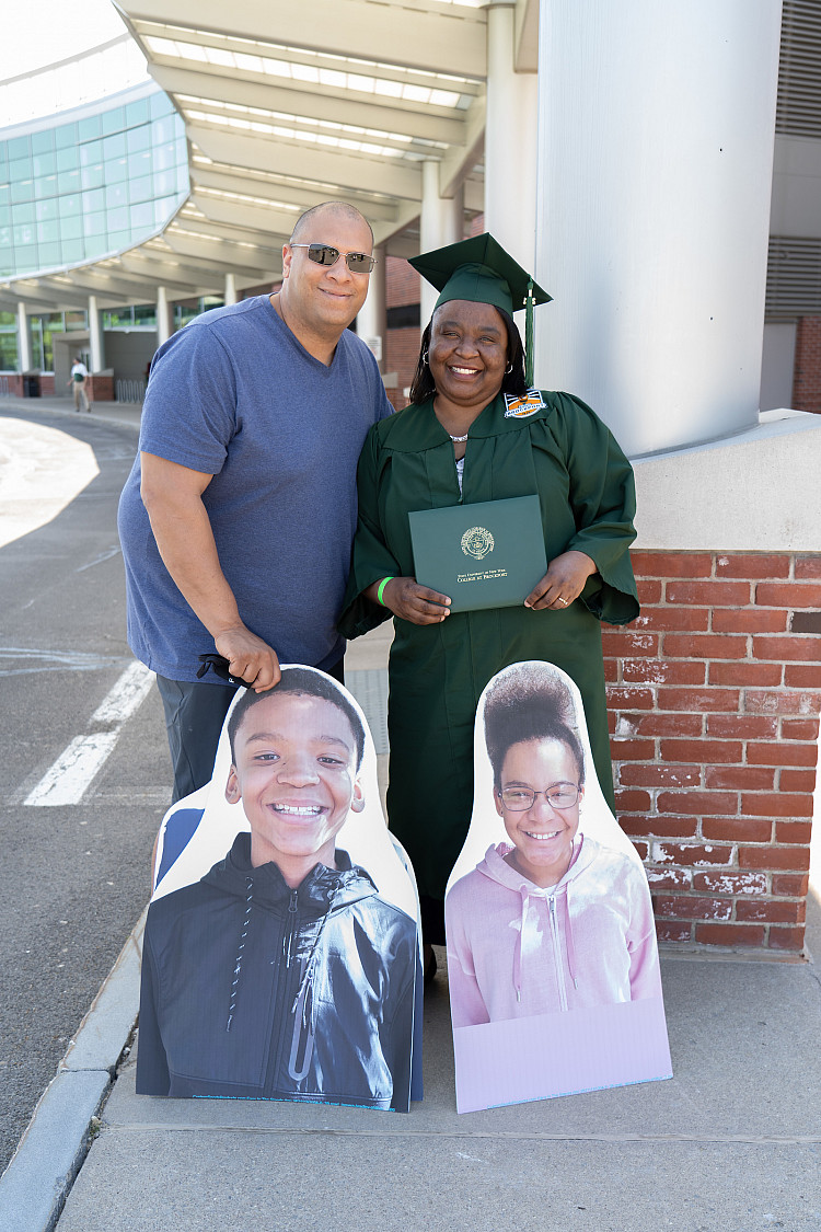 Brockport graduate with their spouse posing for a photo outside of SERC