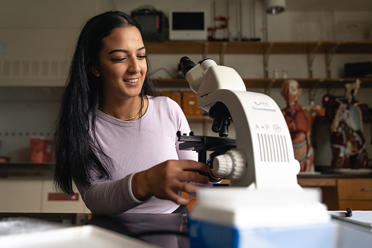 Student looking into a microscope