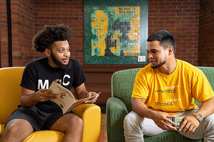 Two students sitting on couches and talking in the Union Main Lounge