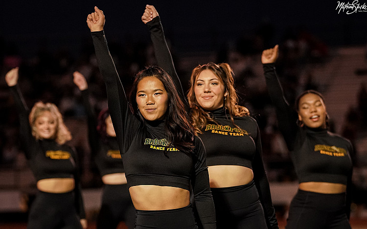 Brockport Dance Team members performing on the field at a football game