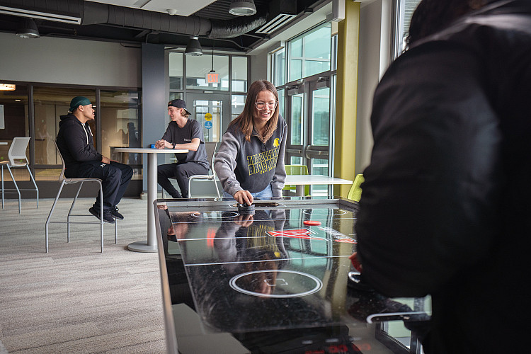 students playing air hockey in Eagle Hall's lounge