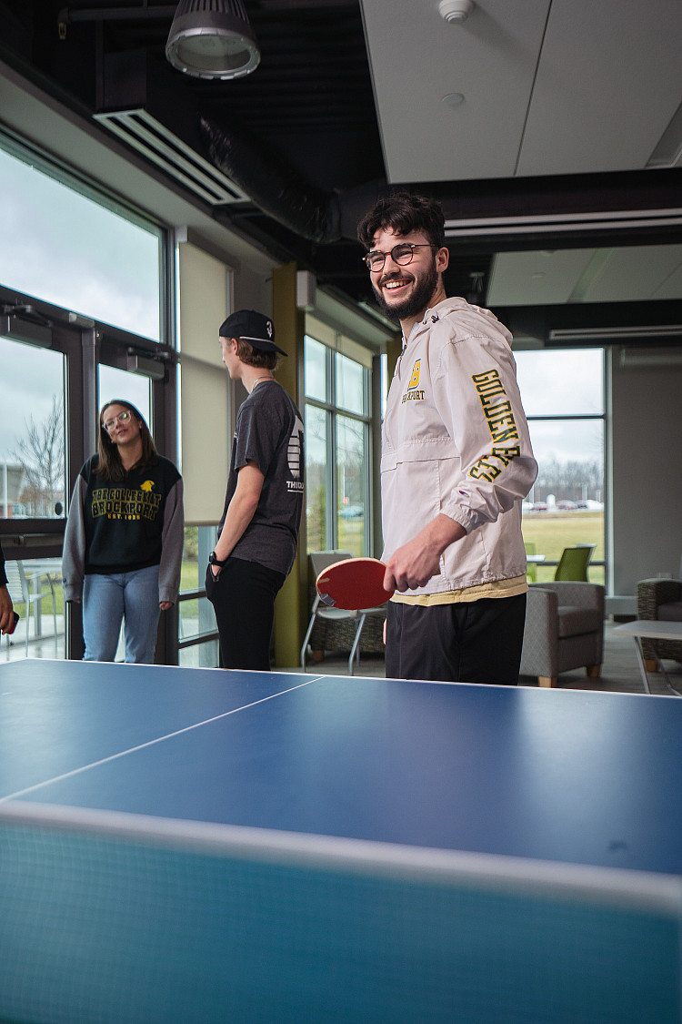 student playing ping pong in Eagle Hall