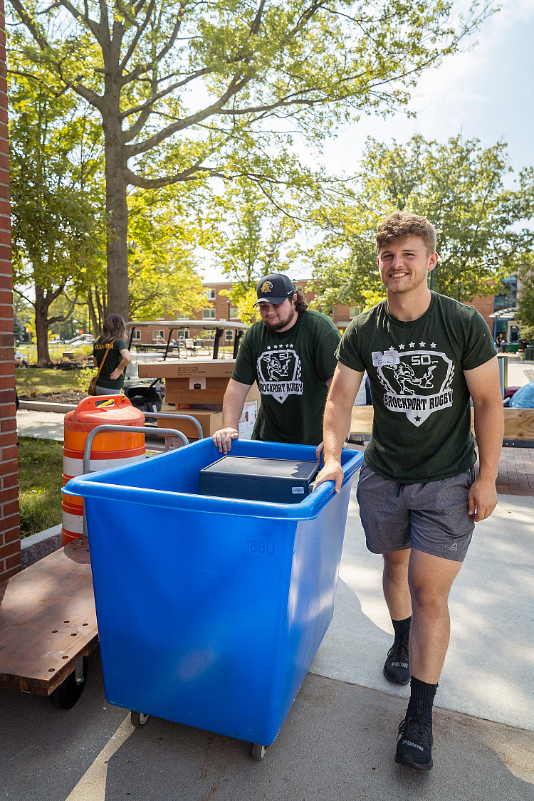 two students pushing a cart on move in day