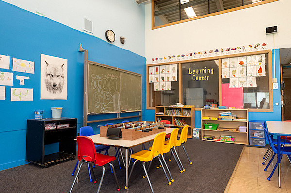 A classroom for children with a table and chairs