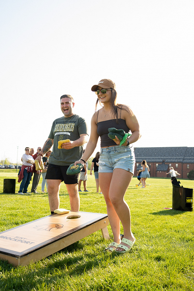 Two students playing cornhole