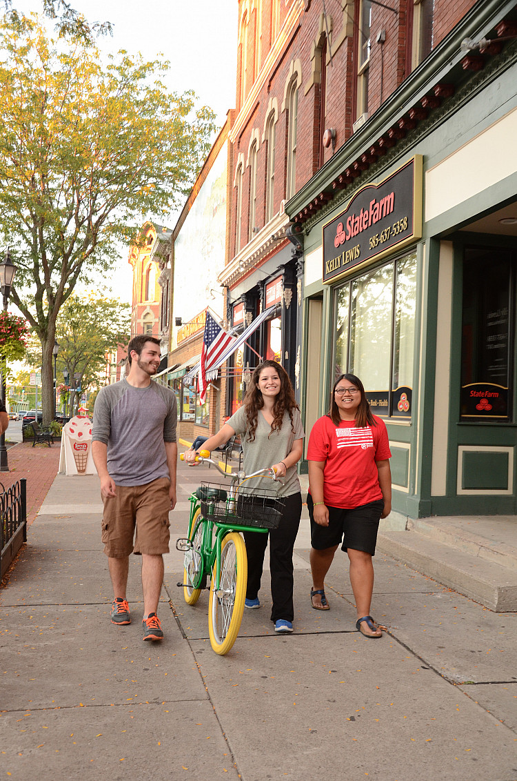 Students walking in the Village of Brockport with Campus Rec bikes