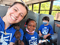 Staff taking a selfie with children on a bus