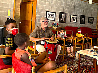 Group of children watching a staff play the drum