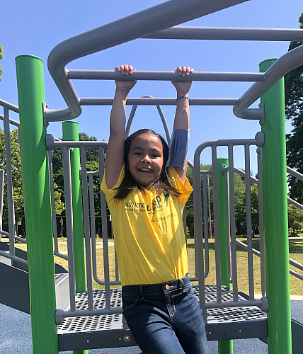 Child hanging on the monkey bars at a playground