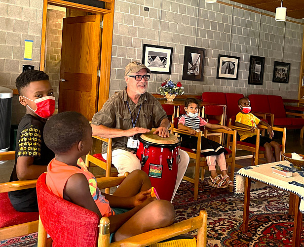 Group of children watching a staff play the drum
