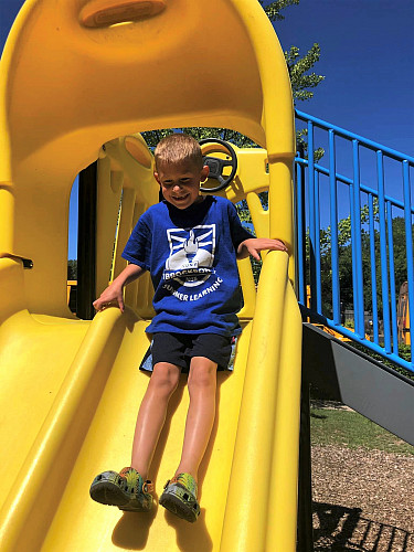 Child sliding down the slide at a playground