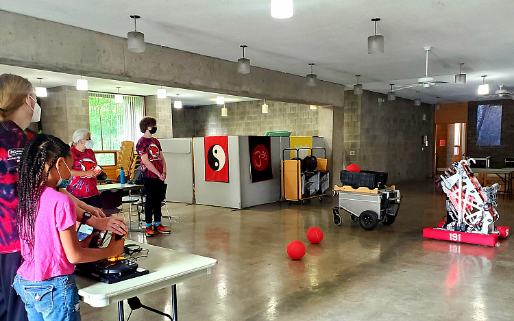Children and staff controlling some robots in a classroom