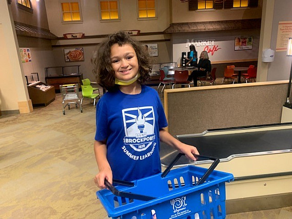Child at a grocery store holding a basket