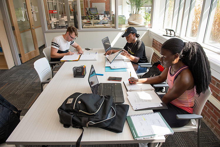 students pictured sitting at a table in the academic success center on campus