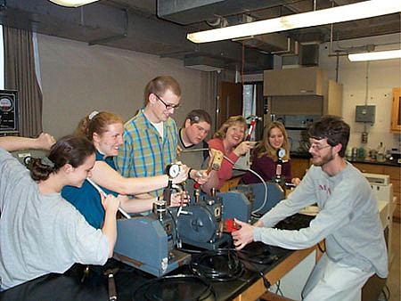 Physical Chemistry Lab II students showing off their repaired vacuum pumps as final result of a hands-on fix-it lab experience in the Spring