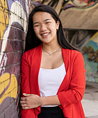Photo of lily wegerski next to the graffiti wall on campus