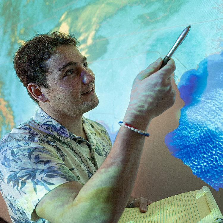 Meteorology student pointing at a forecast map