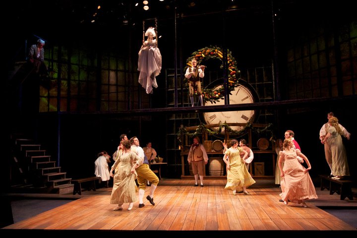 Actors dancing and singing on stage performing A Christmas Carol