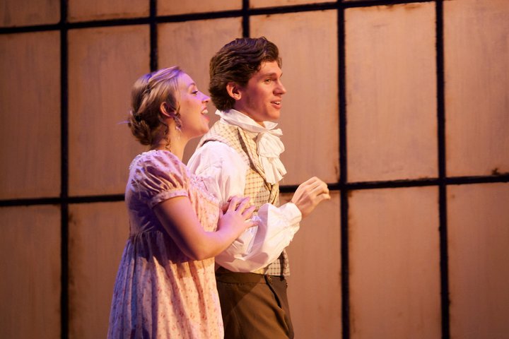 Actor and actress singing together on stage in A Christmas Carol