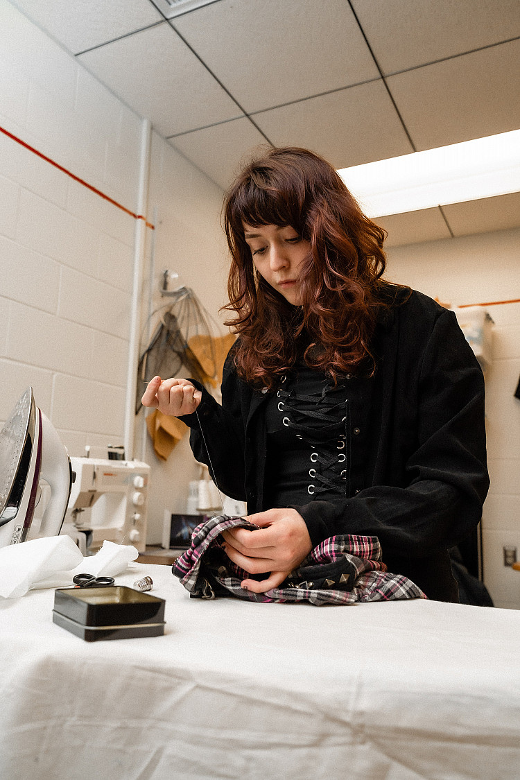 Student working on a costume for a performance