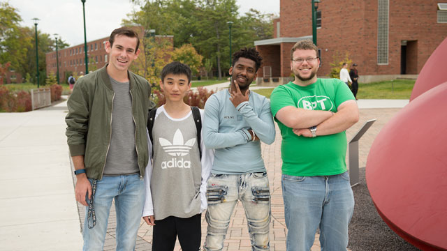 international students smiling Group of four students standing outside and smiling
