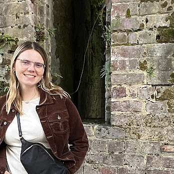 Aimee Albright standing in front of a weathered brick wall