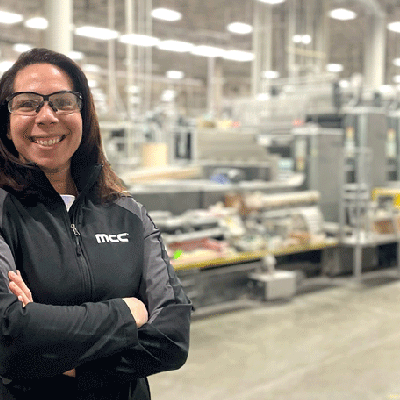 Kim Flynn stands in the production facility at her job