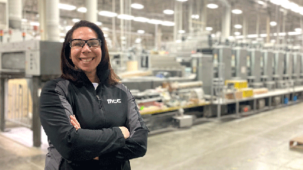Kim Flynn stands in the production facility at her job