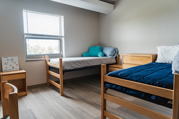 Close up of 2 beds, 2 nightstands, and a dresser in a bedroom