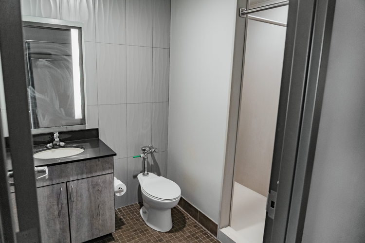 Entrance view of the bathroom of the vanity with a mirror and sink, toilet, and shower stall