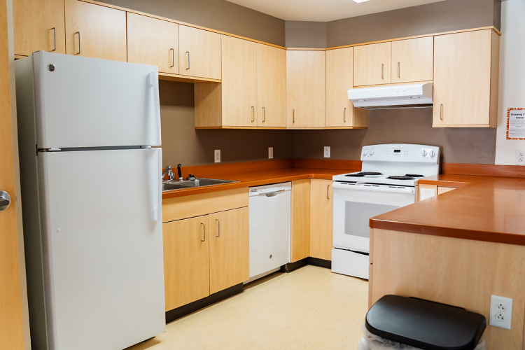 Close up of the U-shaped layout kitchen with a fridge, sink, dishwasher, and stove