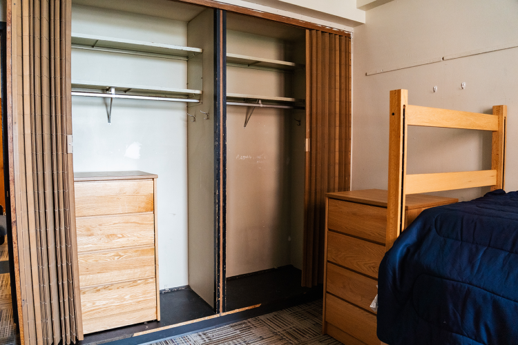 Close view of 2 closet spaces, 1 with a dresser inside