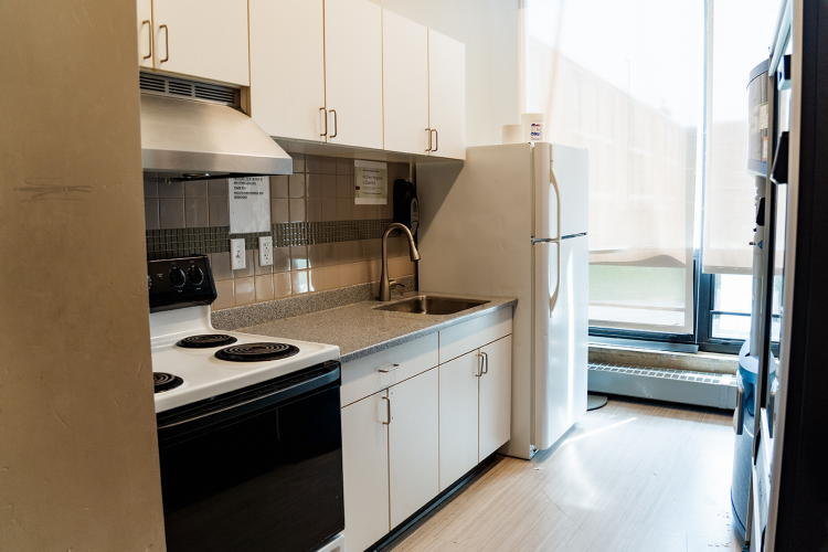 Entrance view of a kitchen with a stove, sink, and fridge