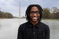 Maxwell Johnson in front of the Washington Monument and smiling.