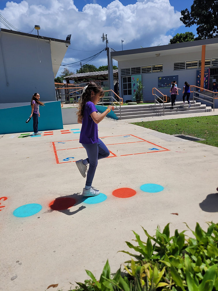 Girl jumping on painted dots