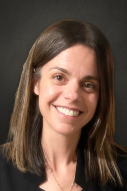Female with long brown hair and brown eyes. She is smiling.
